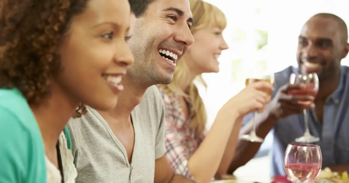 group of friends sitting around a table, throwing a street party
