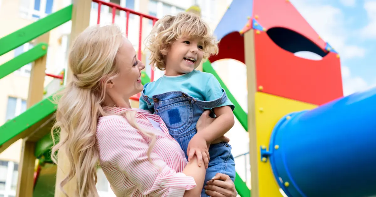 mother and child having fun at the playground in family friendly suburbs